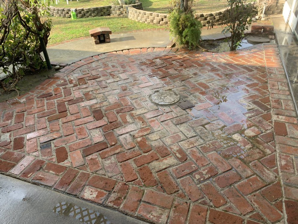 The same brick patio stripped clean and bright after pressure washing