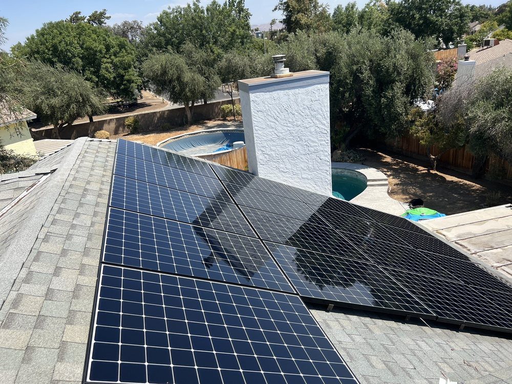 Freshly cleaned rooftop solar panels on a Fresno home overlooking the backyard pool