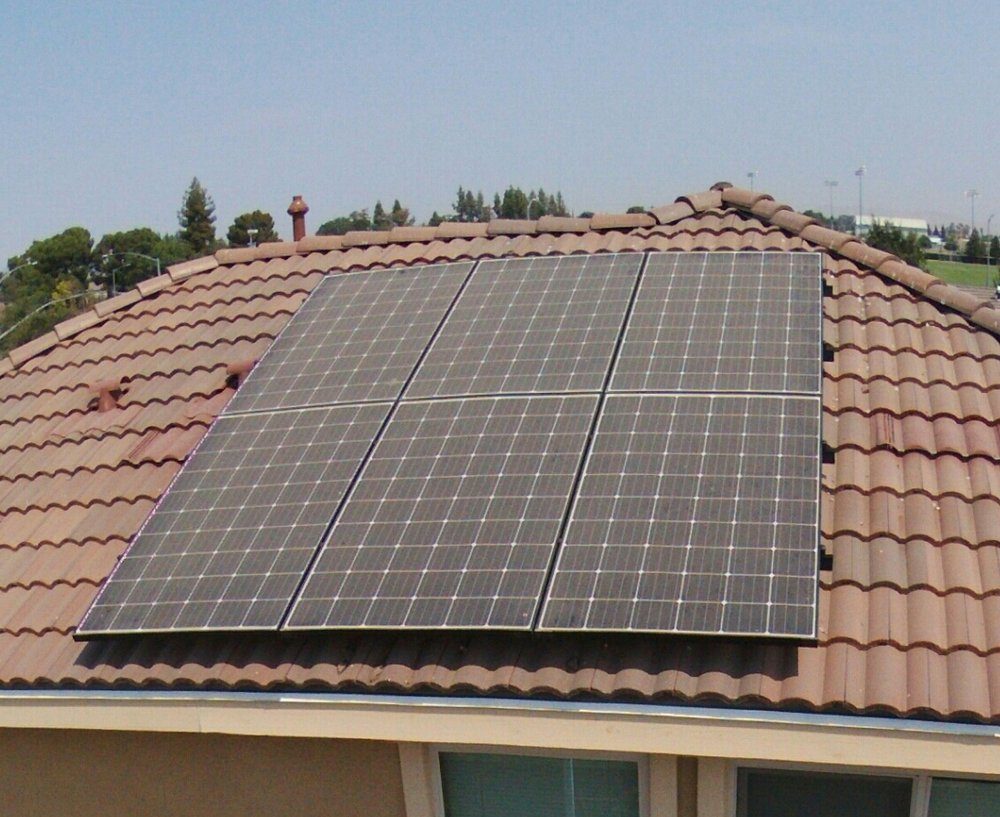 Solar array on a Fresno tile roof dulled by Central Valley dust before cleaning
