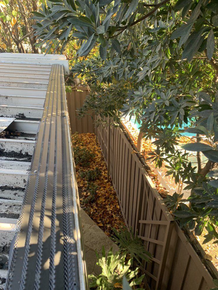 Screened gutter on a Fresno patio cover cleared of packed leaves